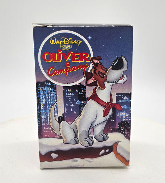 1988 McDonalds Happy Meal ornament of 'Oliver & Company' with a dog and cityscape background