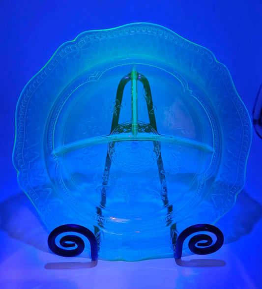 Uranium glass relish dish with decorative stand lit up by blacklight